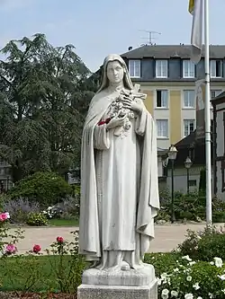 Thérèse aux Roses, marbre blanc, devant le Carmel de Lisieux