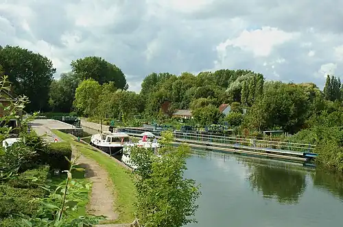 L'écluse dans son cadre verdoyant prisé par les campeurs et les pêcheurs.