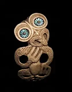 Pendentif hei tiki. Peuple Maori. Os gravé, nacre. H. 10&nbsp;cm. Nouvelle-Zélande. 1850-1950.