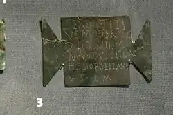 Ex-voto inscrit en bronze en forme de tabula ansata, découvert dans le camp romain de Carnuntum. AE 2005, 1233 : Sextus Titi/us Moderatus / c(enturio) leg(ionis) XIIII G(eminae) / M(artiae) V(ictricis) Iovi Optimo / Helipolitano / v(otum) s(olvit) l(ibens) m(erito).