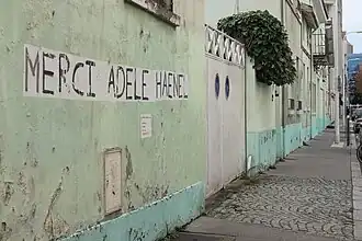 Collage sur un mur marqué « Merci Adèle Haenel » et des coordonnées sur les réseaux sociaux