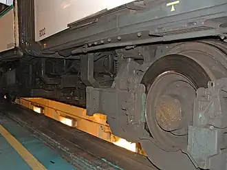 Une roue orientable et l'attelage entre la motrice et la remorque, au premier plan.