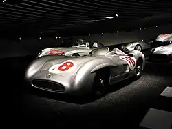 Photo d'une Mercedes-Benz W196 grise frappée du numéro huit, exposée dans un musée