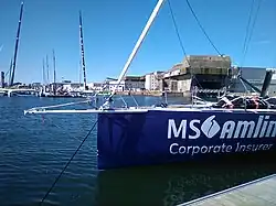 Avant d'un bateau bleu sombre amarré au ponton.