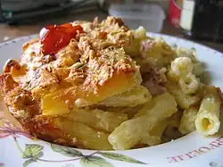 Plat de pâtes gratinées avec de la sauce tomate et une tomate-cerise