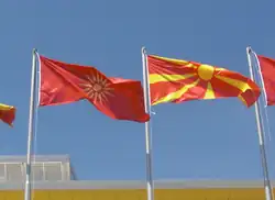 Photographie montrant l'ancien drapeau et le nouveau disposés ensemble au centre sportif Boris Trajkovski