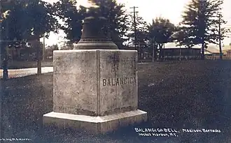 Une cloche sur socle en béton