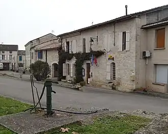 Agence postale et pompe à eau au premier-plan.