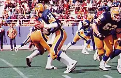 Photo en couleur d'un footballeur américain en tenue bleue et jaune.