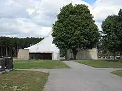 Le mausolée vu de l'axe principal du cimetière avec un arbre le masquant