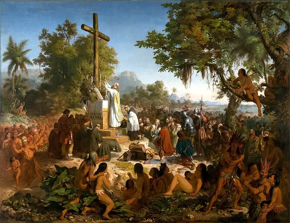 Peinture en couleurs. Une grande croix en bois, positionnée sur un autel au milieu de la nature, est entourée de plusieurs groupes de personnes. À son pied, des religieux et des soldats chrétiens sont en train de prier. Tout au tour d'eux, des indigènes, vêtus de pagnes, assistent à la scène, debout, assis, ou jonchés sur un arbre.