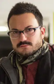 photographie de Michele Pennetta, regard caméra, brun avec lunettes et moustache