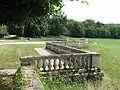 Terrasse avec balustrade en pierres taillées dans le parc.