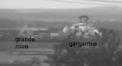 Photographie de deux attractions du parc, la grande roue et la statue gigantesque de Gargantua.