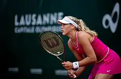 De profil, en position d'attente. Tenue fuchsia.