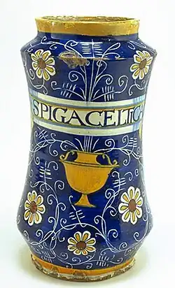 Albarello à décor de graffiti sur fond bleu se terminant par des marguerites, des coupes et un cartouche pharmaceutique, Montelupo, première moitié du XVIe&nbsp;siècle.