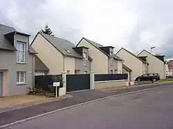 Photographie en couleurs d'une succession de maisons mitoyennes construites sur le même modèle.