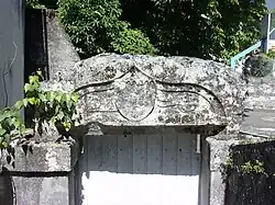 Photographie en couleurs d'une pierre sur laquelle se devinent des gravures partiellement effacées.