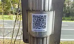 Photographie d'un Munzee (QR Code) sur le dos d'un panneau de signalisation.