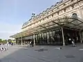 Façade d'un grand bâtiment parisien doté d'un vaste préau couvert.