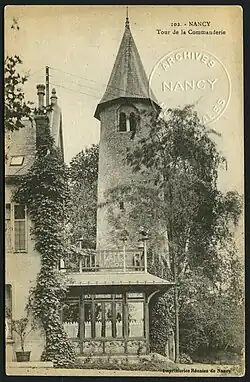 La tour ronde est photographiée depuis l'avenue Foch, entourée de végétation.