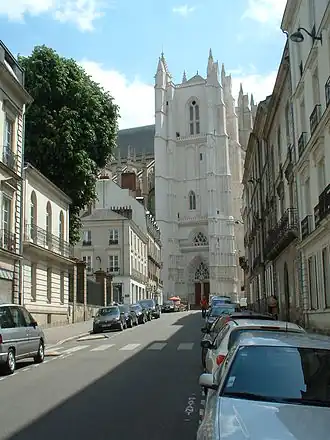 Photo de la rue du Roi-Albert, à Nantes ; elle est longée de bâtiments du XIXe&nbsp;siècle rectilignes et blancs, on voit au fond se dresser la cathédrale de Nantes