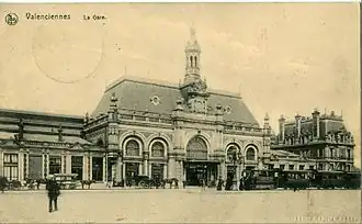 La gare actuelle, avant la Première Guerre mondiale.Devant le bâtiment stationne une rame à vapeur de l'ancien tramway de Valenciennes.