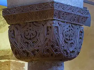 Chapiteau roman cubique sculpté de lions et de fleurs.