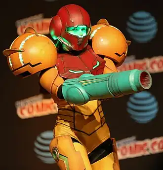 Femme dans un costume jaune et rouge de Samus Aran (cosplay).