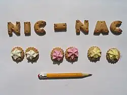 7 nic-nacs en forme de lettre et 6 petits ronds surmontés de sucre glace blanc, rose et jaune