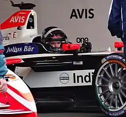 Photo d'une monoplace noire et blanche dans son garage