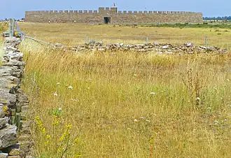 Paysage agricole du sud d'Öland, où était pratiqué le solskifte, avec la forteresse d'Eketorp en arrière-plan.