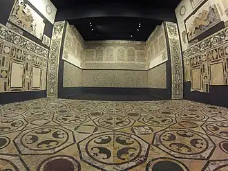 Salle de la domus de la Porte Marine à Ostie, exposé au musée du Haut Moyen Âge de Rome, avec sols et murs entièrement décorés en opus sectile du IVe&nbsp;siècle très bien conservé.