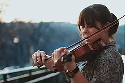 Photographie en couleurs d'une jeune violoniste jouant de son instrument