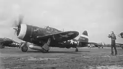 Photographie noir et blanc d'un avion de chasse au sol durant la Seconde Guerre mondiale