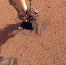 Animation montrant la pelle fixée au bras tassant le sol autour de l'instrument HP3.