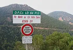 Panneau d'interdiction à la circulation publique (de type B0), avec coordonnées DFCI de l'entrée, nom de la piste et code de la piste dans le massif de l'Estérel.