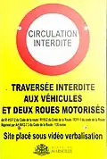 Panneau informant de l'interdiction de circuler à certains véhicules sur la place Jean-Jaurès. Il indique :  « Circulation interdite. Traversée interdite aux véhicules et deux-roues motorisés. Art. R 412-7 2 du Code de la route / R110-02 du Code de la route / R311-1 du Code de la route réprimé par Art. R412-7 3 du Code de la route - 135 euros Site placé sous vidéo verbalisation ». En bas au centre se trouve le logo de la ville de Marseille ainsi que ses armoiries.