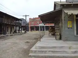 rue traditionnelle d'un western, avec des lignes électriques
