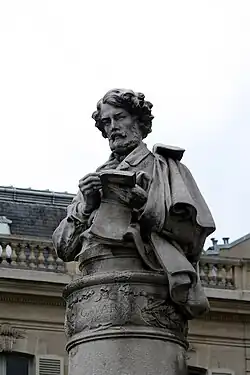 Détail du buste de Gavarni au sommet de la colonne.