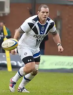 Photographie d'un homme avec un maillot blanc de trois-quart face