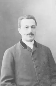 Photographie en noir et blanc d'un homme à moustache.