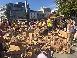 Installation en carton Les Gens construisent (en anglais : The People Build) en cours de destruction par les visiteurs sur la place Eyre (en), lors de l'édition 2017 du Festival international des arts de Galway (en).