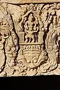 Détail d'un linteau khmer, trouvé au Prasat Bai Baek, style du Baphuon, XIe&nbsp;siècle : Vishnou sur Garuda, surmontant un Kala.