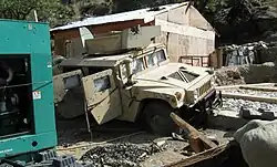 Vue d'un Humvee blindé criblé d'impacts à la COP Keating, gravement endommagé lors de la bataille de Kamdesh.