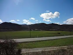 Plaine de la Bléone verdoyante au printemps. Les collines de Chénerilles sont encore noires de l'hiver