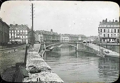 Chargement vers 1900 d'un bateau amarré au pied de la place de la Petite-Hollande près de l'hôtel de La Villestreux. Le palais de la Bourse est sur la rive opposée. Place du Commerce et île Feydeau sont reliées par le pont de la Bourse.