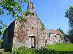 Photographie en couleurs d'un ensemble de bâtiments dont une chapelle à clocher-peigne.