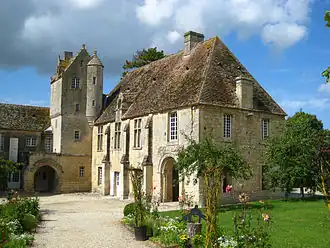 Photographie de l'aile d'un bâtiment dont l'angle intérieur est occupé par une tour en bâtière.