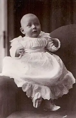 Photographie en noir et blanc d'un petit garçon vêtu de blanc.